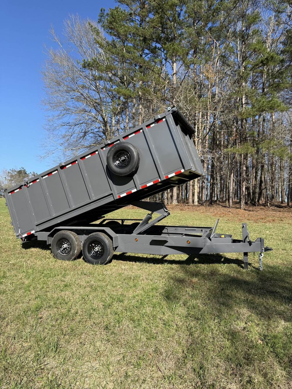 Triple R dump trailer with the bed raised in a field