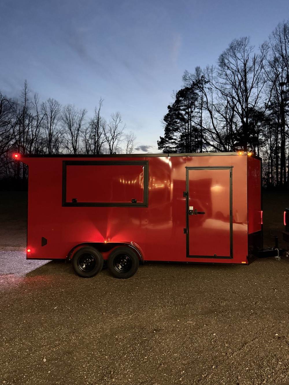 Red enclosed Triple R trailer at night with LED lights on